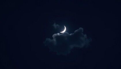  A crescent moon partially obscured by dark clouds in a night sky. The scene conveys a serene and tranquil atmosphere.