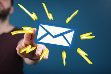 close-up of a man's hand reaching towards a glowing email icon, symbolizing digital communication an