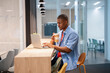 © Santi Nuñez/Stocksy - Focused businessman working on laptop and drinking coffee in office