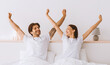 © Prostock-studio - Happy attractive millennial european husband and wife stretching body and enjoying good morning in bed in bedroom interior, panorama. Serenity, energy, weekend and vacation, great mood and relaxation