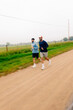 © Adrian Rodd/Stocksy - Motion-blurred wide shot of two friends jogging side by side