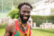 © Tubab Photograph/Stocksy - Happy jamaican man wearing tank top and necklace smiling outdoor