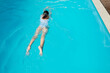 © Evgeniia Siiankovskaia/Stocksy - Girl is swimming in hotel swimming pool at summer.