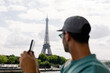 © Adrian Rodd/Stocksy - Blurred close-up of a tourist admiring the Eiffel Tower