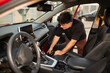 © Hernandez & Sorokina/Stocksy - Man Cleaning Interior of Car in Urban Setting