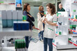 © DC Studio - Diverse women in the pharmacy shop discuss about SPF sun block cream, client looking for a good moisturizing lotion to help with UV light protection. Sunscreen advice recommendation.