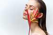 © VICHIZH - Serene beauty portrait with exotic flower on model's face, showcasing tranquility, elegance, and vibrant colors for fashion and wellness themes.