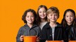 © Aungkana - group of four diverse children smiling brightly against vibrant orange background holding empty orange buckets for activity or celebration