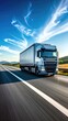 © Canvas - Silver semi-truck speeding down a black highway with a white stripe under a bright blue sky and wispy white clouds in vertical format