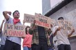 © Gatot - Diverse Group of Young Activists Marching and Holding Up Signs Advocating for Change