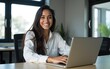 © feng - Portrait young it specialist latin hispanic business lady working on laptop pc sitting at desk in modern office smiling at camera. Middle eastern indian woman using computer technology for work online
