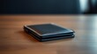 © li - A sleek wallet lies on a wooden surface, highlighted by warm ambient lighting in a minimalist setting.
