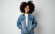 © shuai - Young stylish latina woman student or model in denim jacket standing isolated on background looking at camera. Beautiful curly afro hair african american girl in trendy clothes smile with copy space