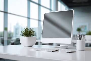 blurred background of a modern office interior with a white desk and computer monitor mockup, a minimalist work space for a graphic designer or web developer, with copy space.