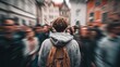 © Rifqi - Back view of a person with a backpack walking through a blurred crowd on city street. Concept for social anxiety, urban exploration and travel experiences