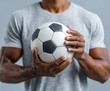 © Her - A man's strong arms hold a soccer ball covered in water droplets, showcasing athleticism and focus against a neutral backdrop.