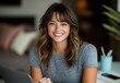 © burntime555 - Smiling young woman with brown hair works on laptop at home