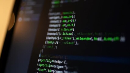Macro Shot of Dark Computer Screen Displaying Green and Blue Code Close Up