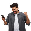 © yendisupiandi - Euphoric young man celebrating success with mobile phone on transparent setting