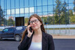 © Alexander - Business people. Portrait of a cheerful young woman talking on the phone on the street.