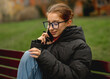 © tan4ikk - Girl In Glasses Talking On The Phone On A Bench In Spring