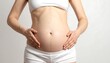 © Atit - Pregnant woman gently touches her growing belly, showcasing a soft, pregnant form against a neutral backdrop.