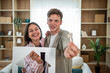© Migma_Agency - Happy couple showing new house keys and paper house symbol
