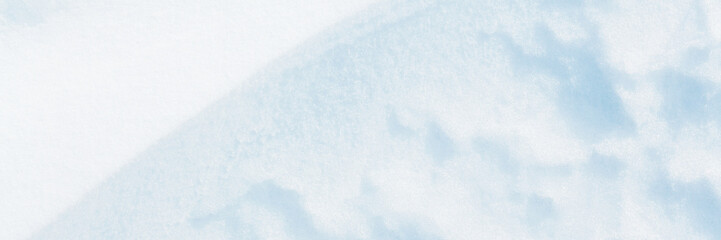 Wall Mural - Wide panoramic winter background with snowy ground. Natural snow texture. Wind sculpted patterns on snow surface.