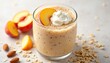 © Vadym - Creamy peach smoothie topped with whipped cream and a peach slice. Contains oats and almonds for a healthy breakfast or snack option. Refreshing and delicious.