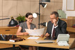 © Pixel-Shot - Lawyers with papers holding meeting at table in office