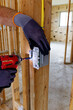 © Andrei Liashchou - Electrician installing GFCI electrical outlet in wooden frame house, USA construction