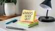 © Haraz - Motivational Sticky Notes with Inspirational Message on Bright Colored Paper on Desk with Pen and Lamp