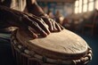 © Michael - Close-up of hands playing a djembe drum in a warm, sunlit room