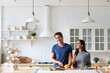 © BestForYou - Couple in the kitchen preparing a dish from healthy vegetables, chatting happily, balanced nutrition.