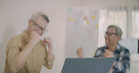 Asian senior adults celebrate success with high five after completing coding lessons, showing teamwork, achievement, and joy in technology education.