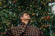 © Masson - stylish European man in a vintage brown wool blazer stands contemplatively by an apple tree