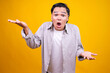 © Gatot - Surprised Young Asian Male Presenting With Open Palms Isolated On Yellow Background