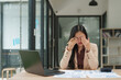 © Phimwilai - Stressed asian businesswoman rubbing eyes at office desk