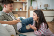© Migma_Agency - Young couple relaxing on sofa, enjoying coffee and conversation at home
