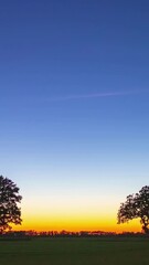 Wall Mural - Dawn timelapse as soft light gradually reveals fields and sky shifting from night to day