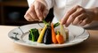 © Luna - Chef preparing colorful vegetable dish.