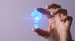 © SYATRI RAWU - Futuristic concept with a hand holding a glowing digital question mark, representing online support, problem-solving, and finding answers