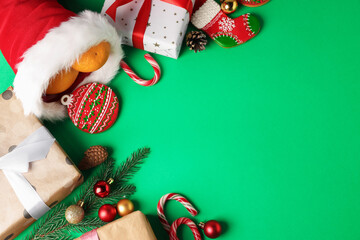 Wall Mural - Saint Nicholas day. Different treats, festive decor and gift boxes on green background, flat lay. Space for text