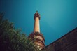 Looking up at the ancient bell tower against a clear summer sky, showcasing historic architecture and urban scenery