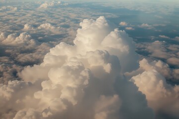 Wall Mural - A stunning bird's-eye perspective of soft white clouds floating over a dark blue backdrop with shadows stretching across the land beneath.
