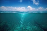 Underwater bubbles and sky with clouds, half submerged perspective of the ocean