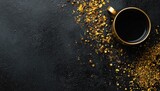 Golden mug of dark drink amidst scattered herbs and spices on black background