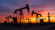 © Taufiq - Silhouetted Oil Rig Derricks Against a Dramatic Sunset Sky Over a Field With Vibrant Colors
