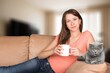 © BillionPhotos.com - Young happy woman drinking tea at home with cat
