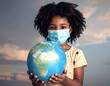 © tanti - Child holding Earth globe, wearing mask